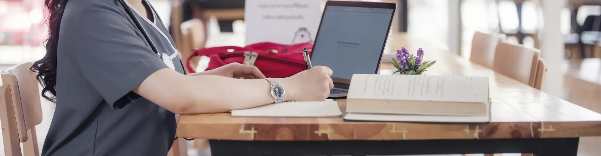 medical student wtih textbooks and laptop