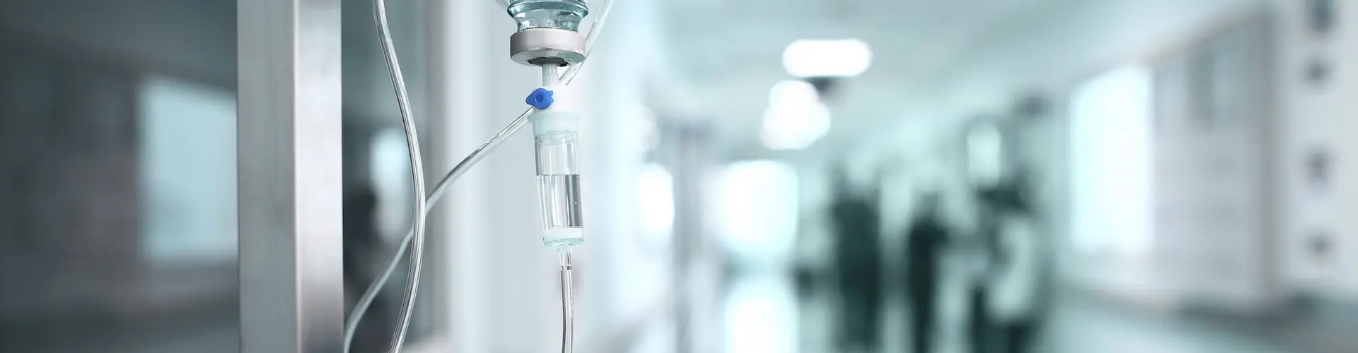 View of a hospital corridor with an IV drip in the foreground