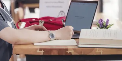 medical student wtih textbooks and laptop