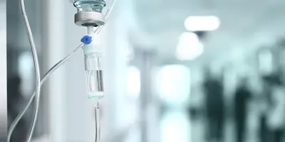 View of a hospital corridor with an IV drip in the foreground
